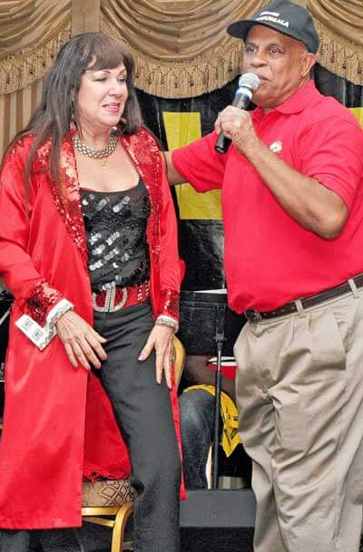 Everybody's Magazine Publisher, Herman Hall announcing Denyse Plummer as a recipient of a Trinidad & Tobago National Medal.