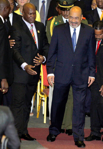 Suriname's President Desi Bouterse, right, arrives to his inauguration accompanied by his former political enemy Ronnie Brunswijk, leader of the Maroons or descendants of runaway African slaves, in Paramaribo, Suriname, Thursday, Aug. 12, 2010 in this file photo.