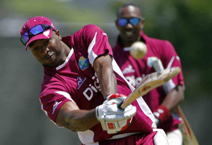 West Indies' Kieron Pollard bats as his teammate Dwayne Bravo looks on during a practice session in Kingstown, St. Vincent.