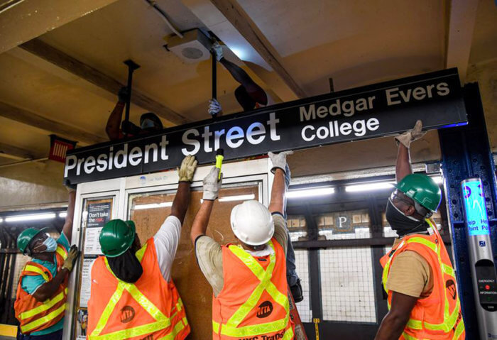 MTA workers installing new singage at the President Street subway station.