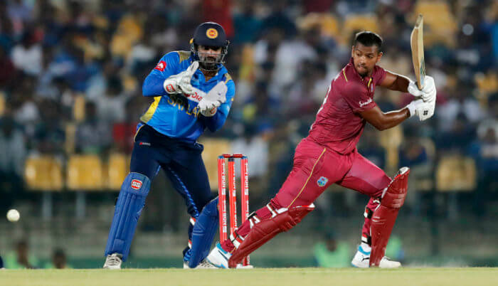 Nicholas Pooran plays a shot as Sri Lankan wicketkeeper Kusal Perera watches during the second one day international cricket match between Sri Lanka and West Indies in Sooriyawewa, Sri Lanka, Wednesday, Feb. 26, 2020. 