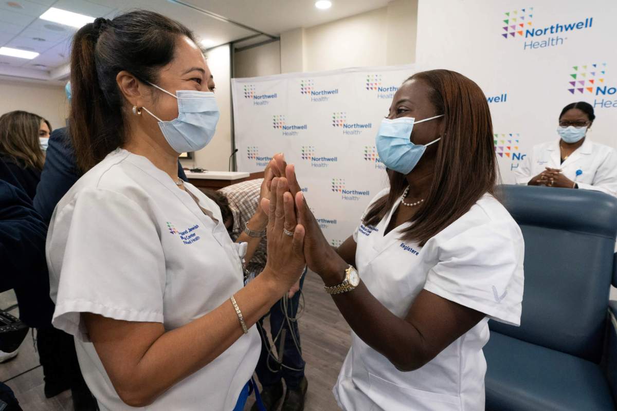 Nurse Annabelle Jimenez, congratulates nurse Sandra Lindsay after she is inoculated with the COVID-19 vaccine, at Northwell Health at Long Island Jewish Medical Center in New Hyde Park, New York
