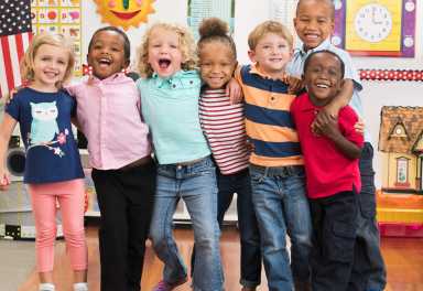 Portrait of smiling students hugging in classroom