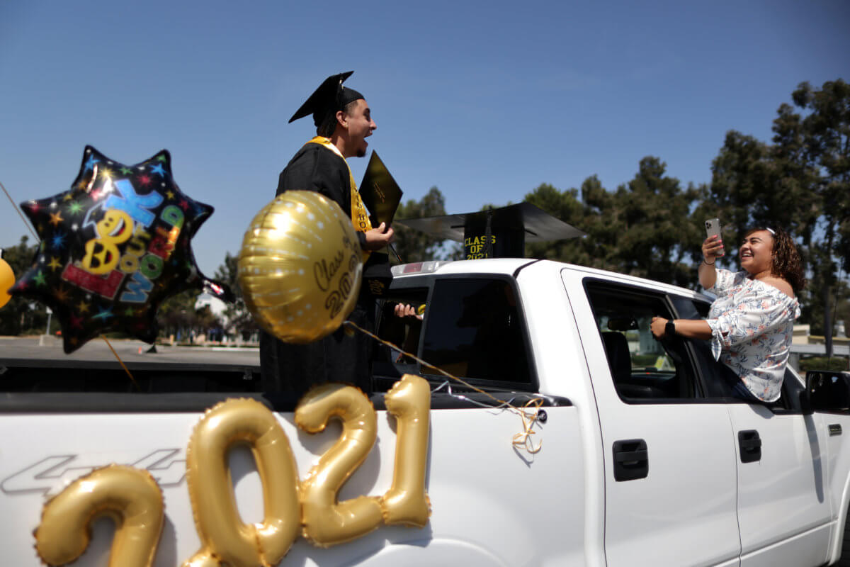 Student Angelo Gallardo, 24, takes part in a drive-through graduation at Rio Hondo community college, as the coronavirus (COVID-19) disease continues, in Whittier, near Los Angeles