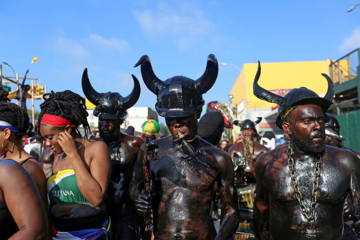 A man wears horns and black oil on his body during the J’Ouvert parade in New York