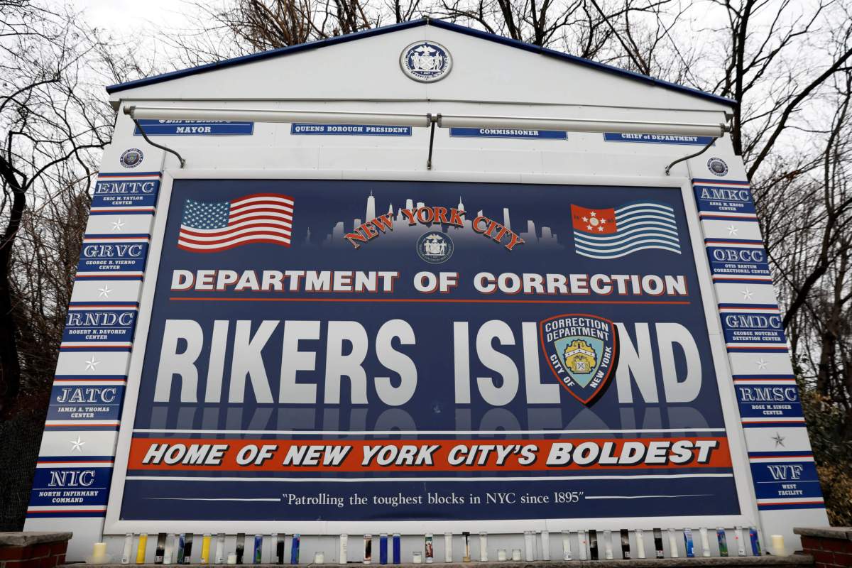 FILE PHOTO: Candles are seen on the sign marking the entrance to the New York City Department of Corrections Rikers Island facility in Queens, in New York