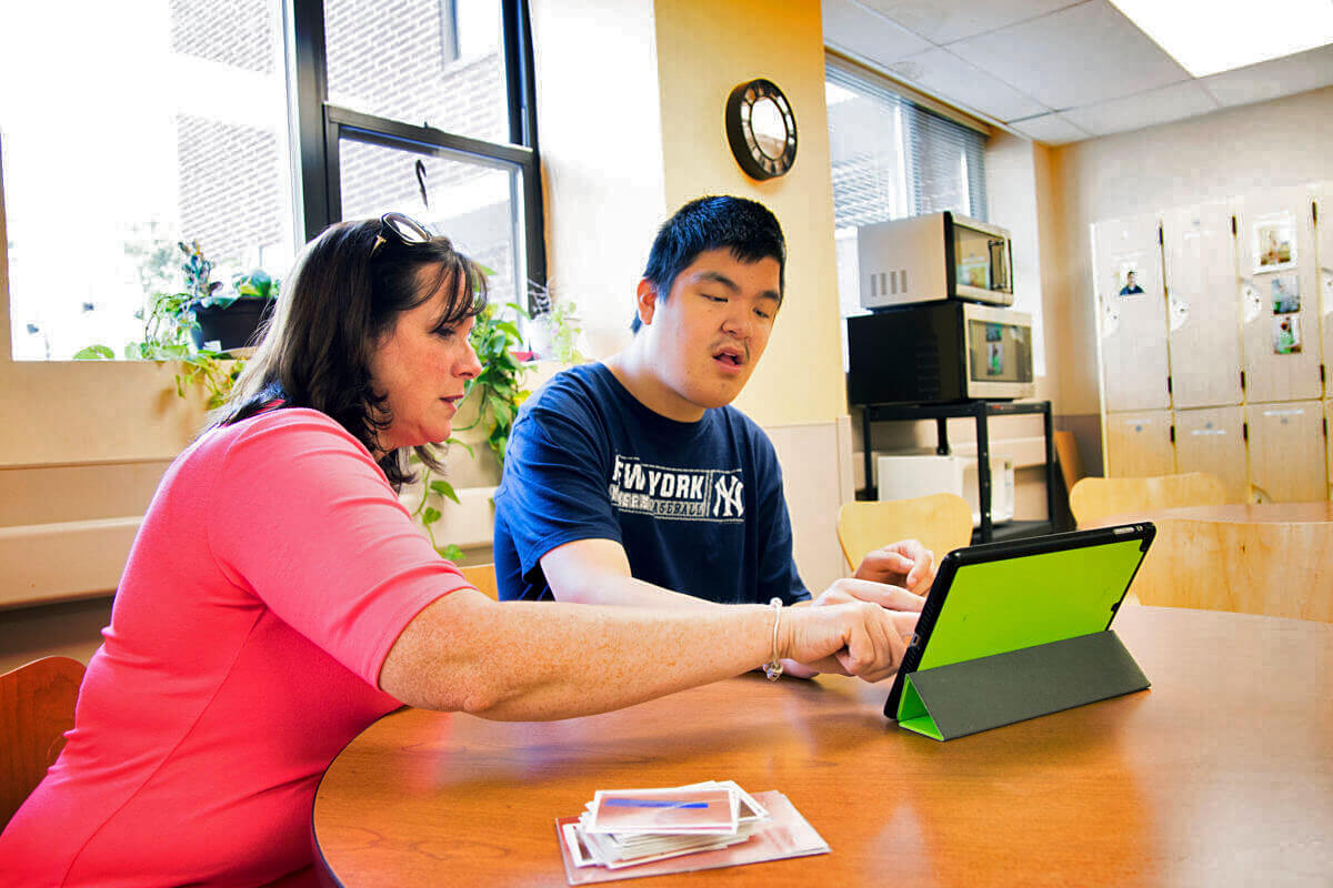 A direct support professional works with a student.  HeartShare Human Services