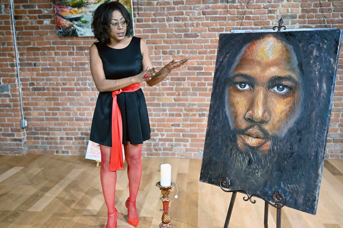 Trinidadian Artist Alicia Aberdeen-Jones with her rendering of David Michael Rudder at Paintings In The Garden III. Oil, 24Kt Gold and pure Silver on 36” x 48” Gallery Wrap canvas.
