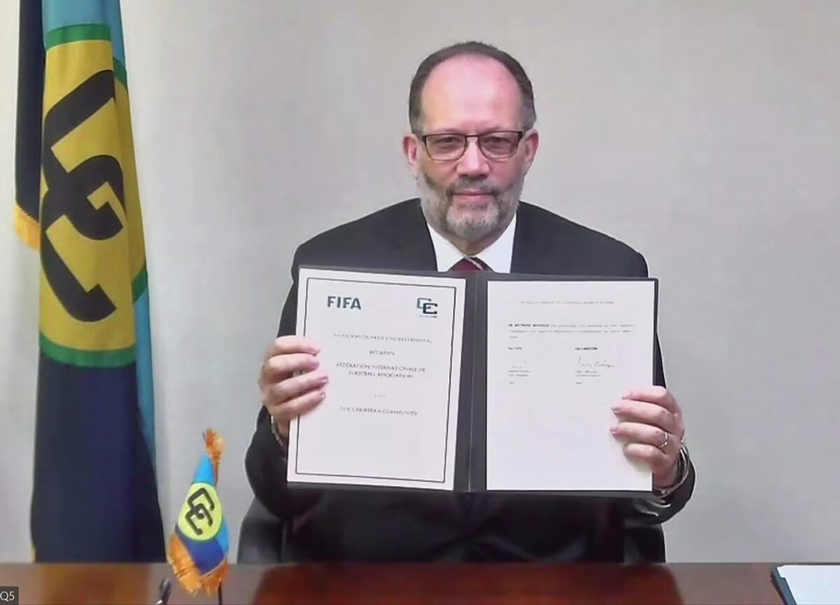 Former CARICOM Secretary General Irwin LaRoque displays MOU.   FIFA