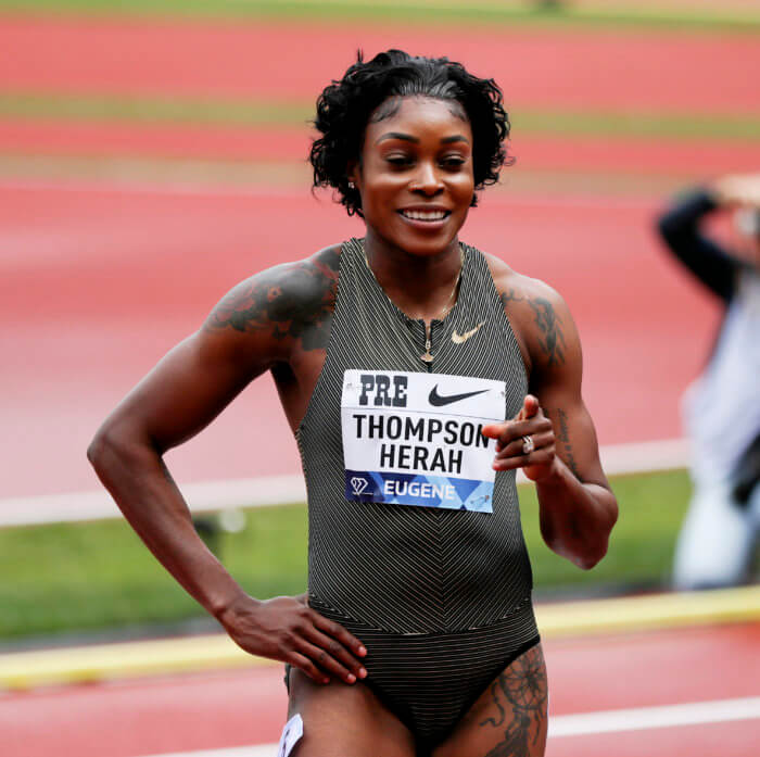 Jamaica's Elaine Thompson-Herah poses for photos following her win in the women's 100 meters during the Prefontaine Classic track and field meet Saturday, May 28, 2022, in Eugene, Ore.