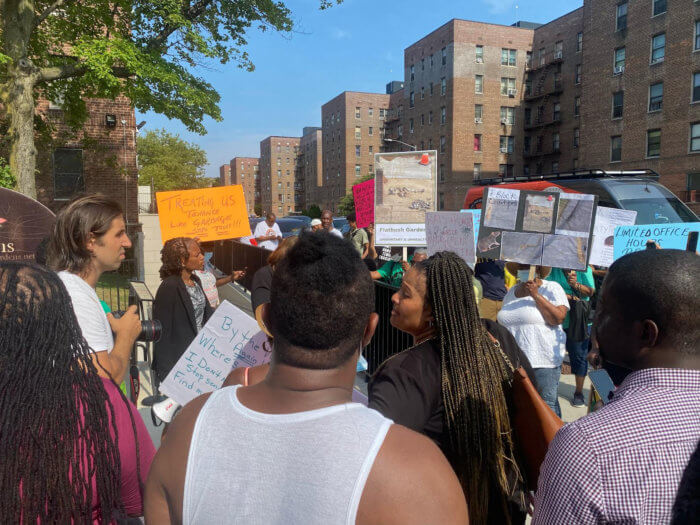 Residents hold up placards demanding better living conditions at Flatbush Gardens housing complex in Brooklyn. 