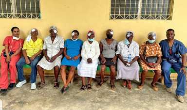 ACPNY's Dr. Anika Michael, far left, and Dr. Benjeil Edghill, far right, sit with patients they cared for on medical mission to Haiti.