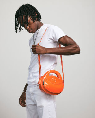 Antoine Manning models his 'Homage Year Mini Solaris Orange Ova Bag.'