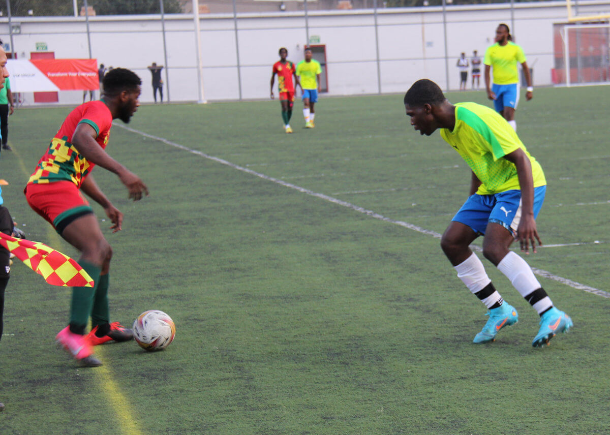 A Grenadian player (in red) tries to bypass a SVG defender.