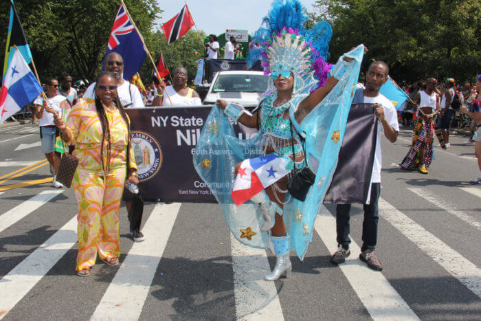 Assembly Member Nikki Lucas, left, leads her 60th District in Brooklyn, with masquerader Cora Cofield at right. 