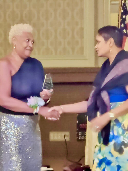 Past president, Lorraine Croft-Farnell accepting the award from current President Naline Persaud-McMillan, at St. Rose's High School 28th Anniversary Awards Gala.