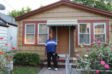 Trinidadian-born Nestor Jasper poses outside his home in Canarsie, Brooklyn where three seasons of the critically acclaimed movie, "The Godfather of Harlem" was filmed.