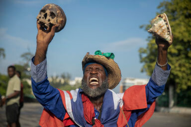 A protester holding up a skull and seashell shouts for the resignation of Haitian Prime Minister Ariel Henry in the street in the Champs de Mars area where the prime minister attended a ceremony marking the death anniversary of revolutionary leader Jean-Jacques Dessalines in Port-au-Prince, Haiti, Monday, Oct. 17, 2022.