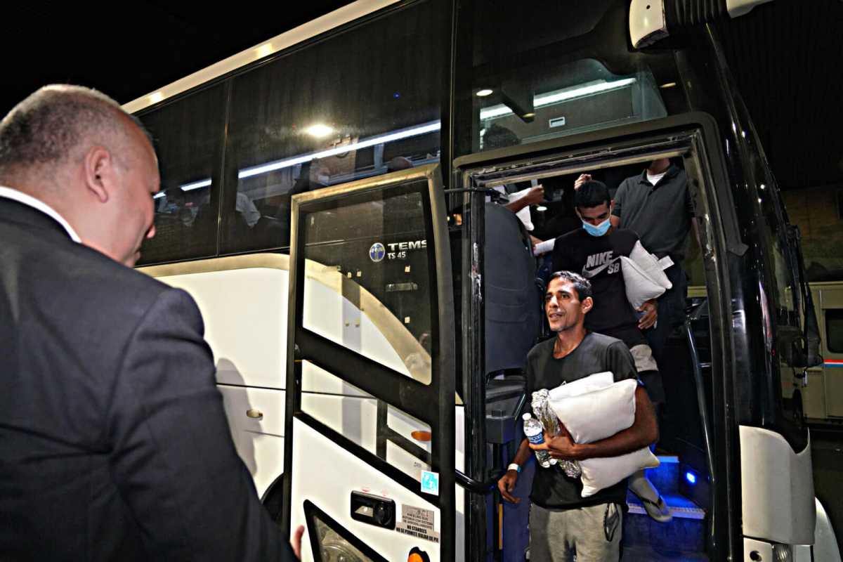 Migrants disembark the bus.