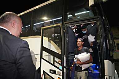 Migrants disembark the bus.