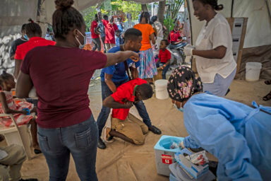 A youth suffering from cholera symptoms is helped upon arrival at a clinic run by Doctors Without Borders in Port-au-Prince, Haiti, Thursday, Oct. 27, 2022.