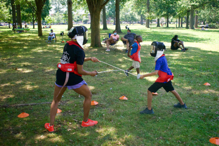 Nzingha Prescod and Chase fencing in the park. 
