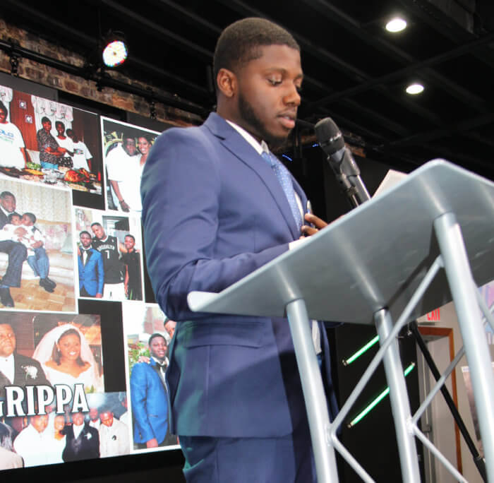 Joshua Agrippa reads the obituary.