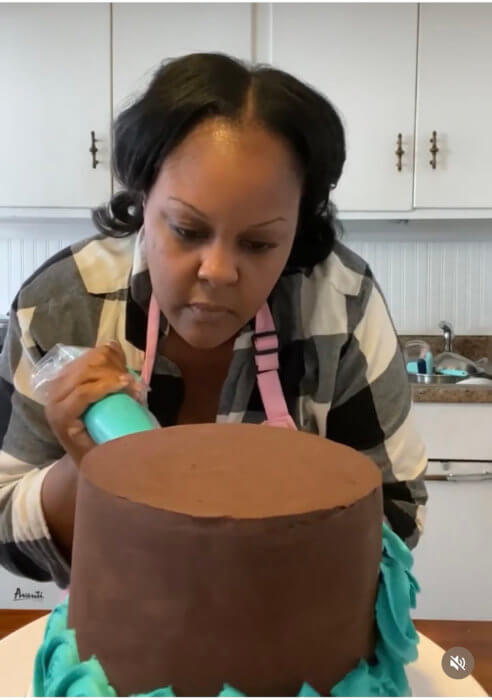 Instagram photo of De'Lor Cakery Founder and CEO Kayisha Thompson, decorating a cake.