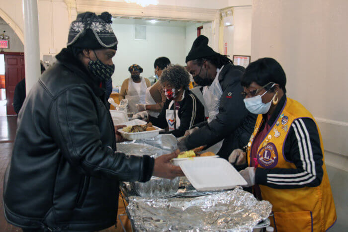Volunteers serve Thanksgiving meal.