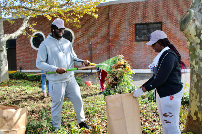 Longtime volunteer Nicholas Horsford, assists a volunteer with cleaning up a flowering bed before the planting of daffodil and tulip bulbs.