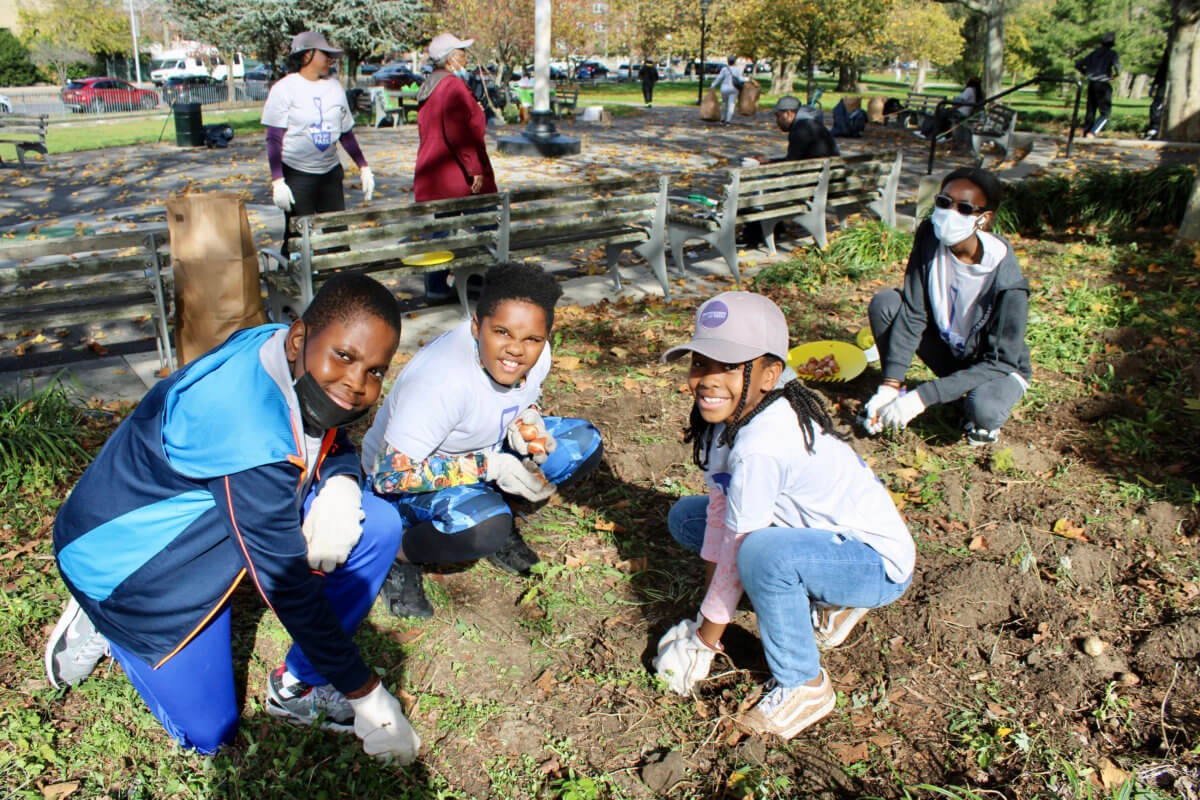 Josiah and Noah, left, join other youths in planting tulip and daffodil bulbs on the prepared patch of ground in Seaview Park, Canarsie, Brooklyn.