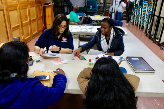 Guyanese nationals being attended to by staff, Fazia Khusia, and Niacifa Watson, during the first Brooklyn Outreach, at Restoration Temple Assembly of God in Brooklyn, on Nov. 19.