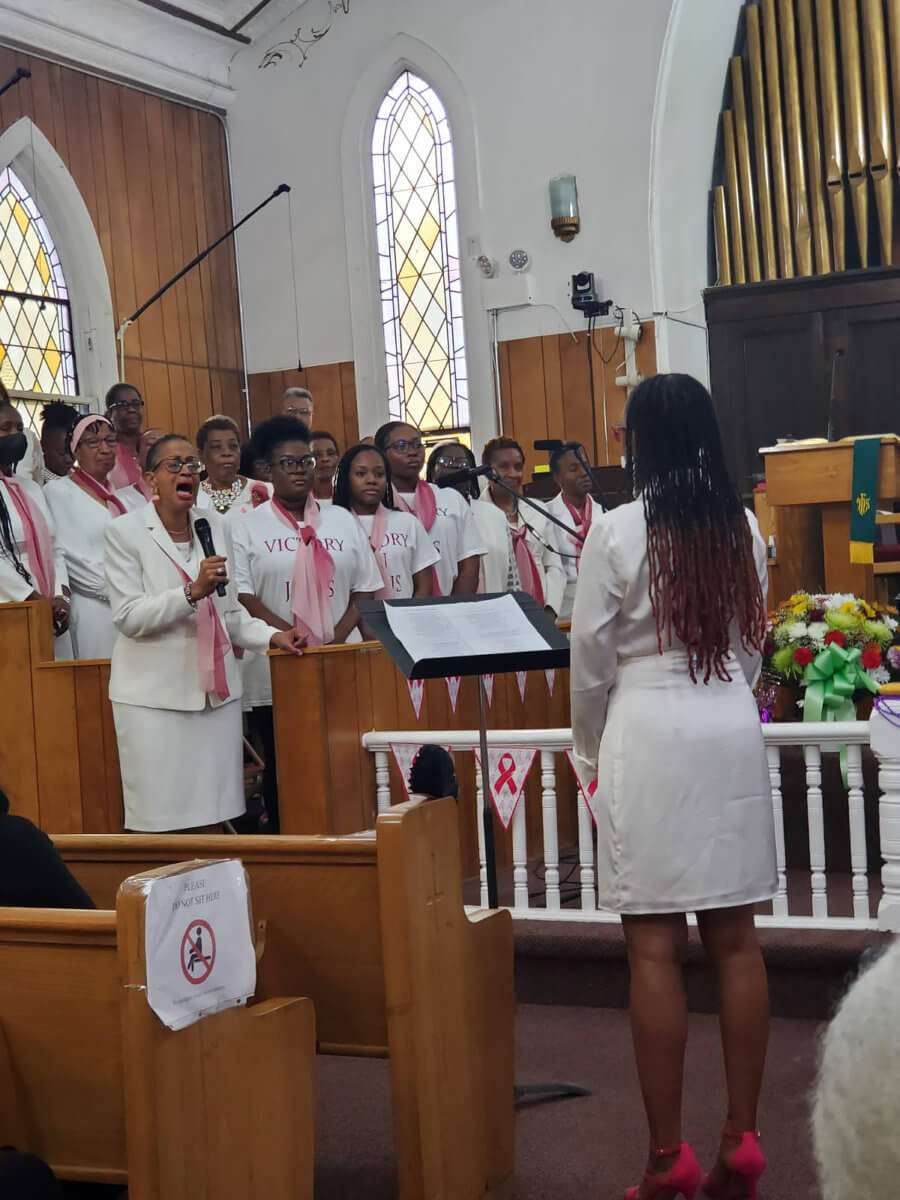 Anniversary Choir wears pink ombre and sings “My Help” by composer Bam Crawford. The performance was directed by Sis. Barbadian Sophia Eversley, with Sis Trinidadian Patricia Senhouse as soloist.
