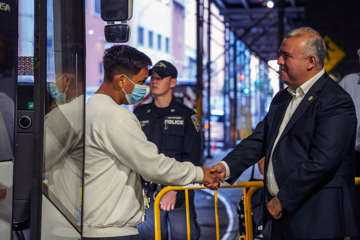 Mayor’s Office of Immigrant Affairs Commissioner Manuel Castro shakes hands as migrants step off the bus.