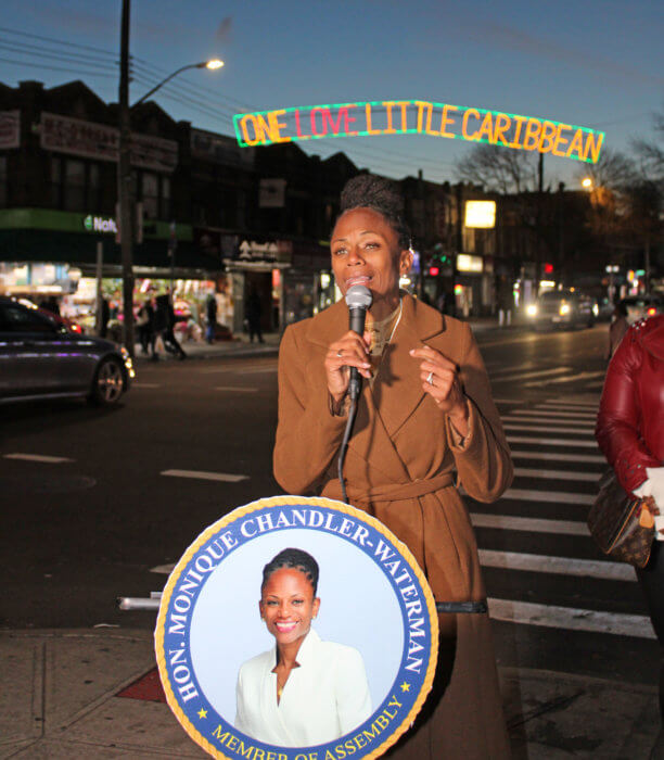 Assemblywoman Monique Chandler-Waterman addressed a large crowd at the intersection of Utica and Church avenues, with the first One Love Little Caribbean holiday lights in the background. 