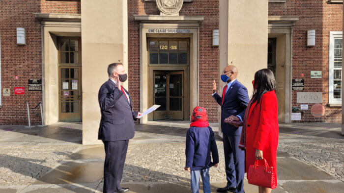 Donovan Richards takes the oath flanked by his wife and son. 