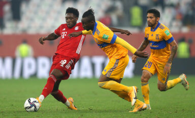 Alphonso Davies of FC Bayern Muenchen passes the ball under pressure from Julian Quinones of Tigres UANL during the FIFA Club World Cup Qatar 2020 Final between FC Bayern Muenchen and Tigres UANL at the Education City Stadium on Feb. 11, 2021 in Doha, Qatar.