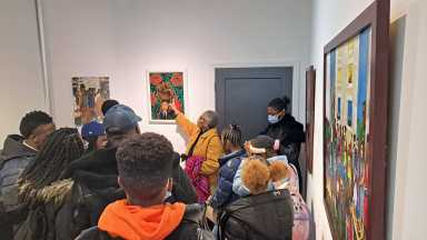 Artist Aleathea Sapp Jimenez speaking about her artwork to the attendees.
