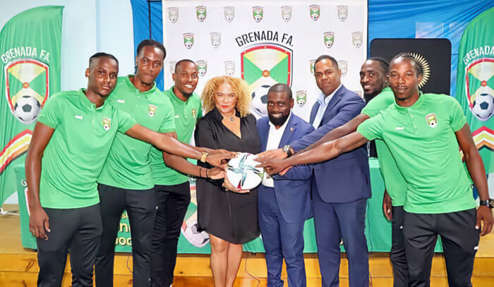 Petra Roach, CEO of the Grenada Tourism Authority (fourth from left); Hon. Ron Redhead, minister with responsibility for Youth, Sports and Culture (center right); and Marlon Glean, president of the Grenada Football Association (sixth from left) pose for a photo with the members of the Grenada Senior Men’s National Team.