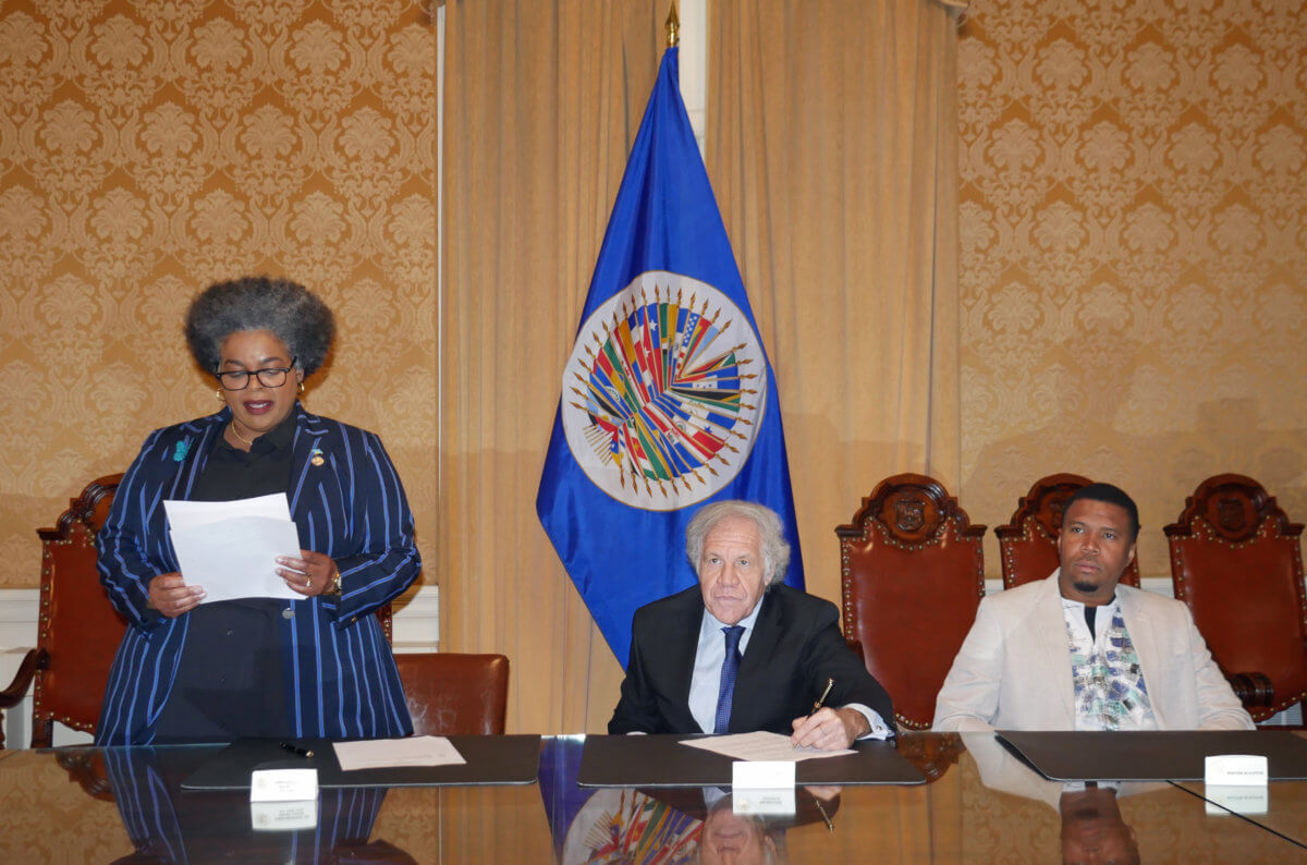 Permanent Representative of St. Lucia, Elizabeth Darius-Clarke, addresses the gathering while OAS Secretary General Luis Almagro and artist Jallim Eudovic look on.
