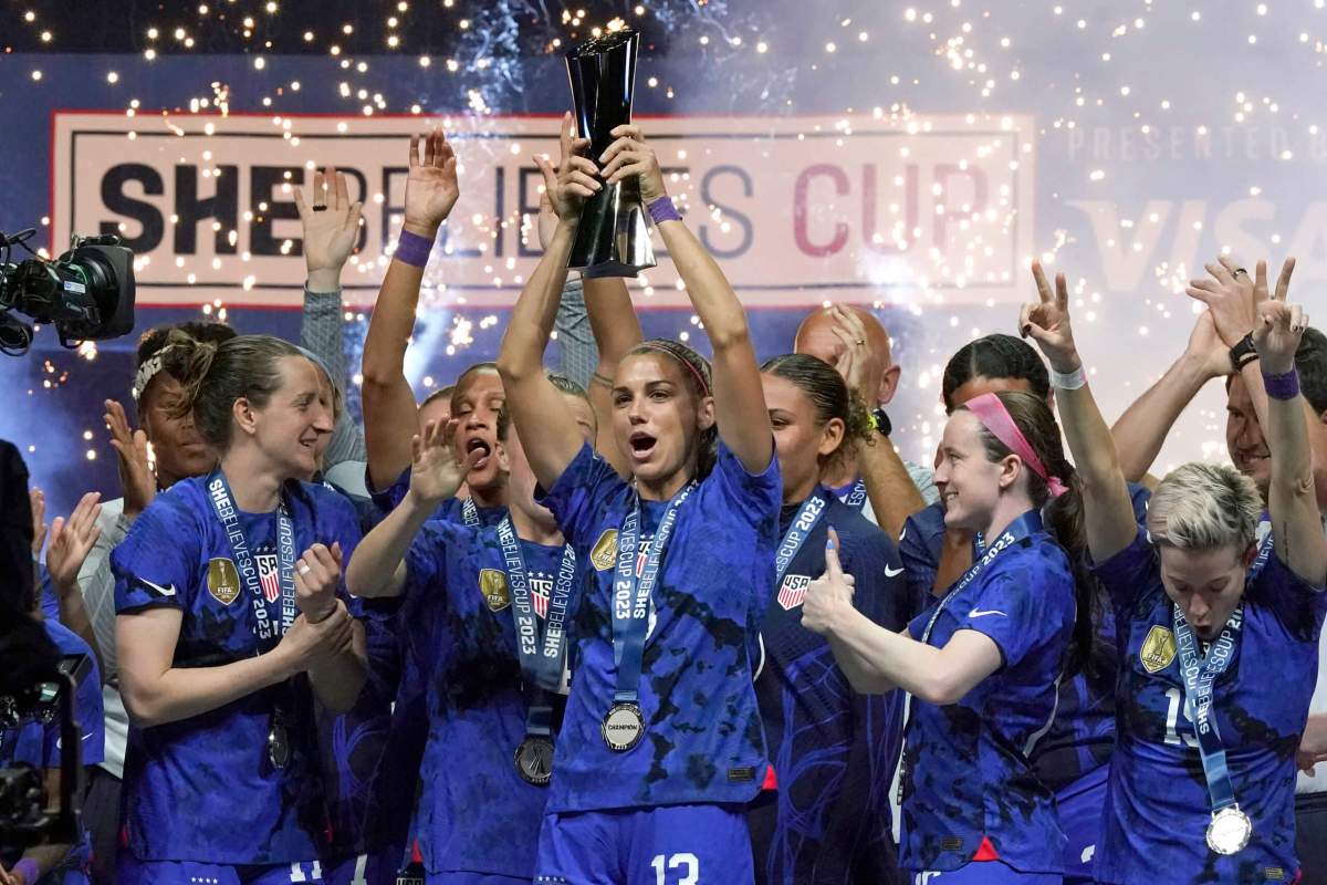 United States forward Alex Morgan, center, lifts the SheBelieves Cup with teammates after they won a soccer match against Brazil 2-0 Wednesday, Feb. 22, 2023, in Frisco, Texas.