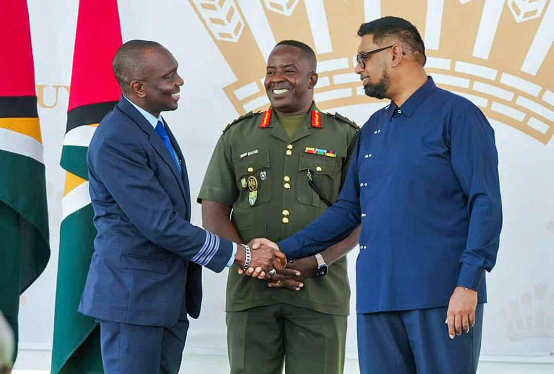 First Officer Haslyn Peters shakes the hand of President Irfaan Ali, as Chief of Staff of the Guyana Defense Force, Brigadier General Godfrey Bess, looks on.