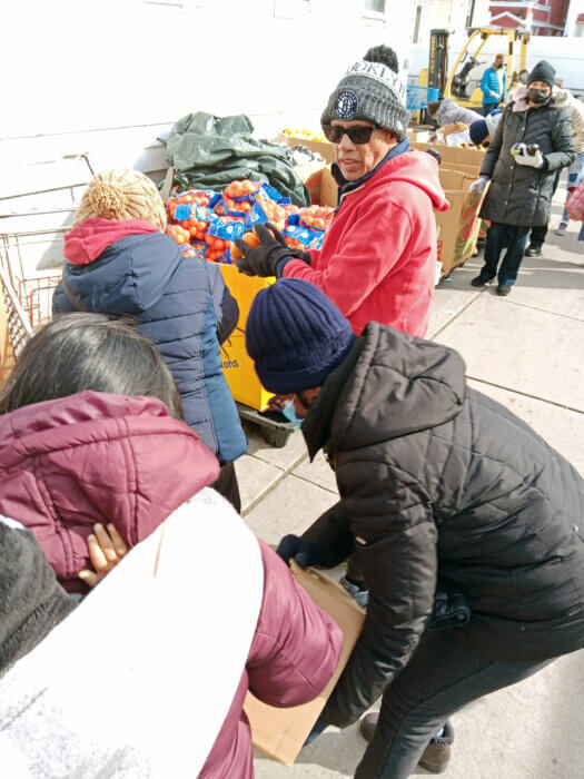 Founder of Calvary's Mission Food Pantry, Tony Singh, who arrives promptly at 5a.m. every Saturday, is seen handing out oranges at the 102-16 89th Ave., Richmond Hill, Queens.