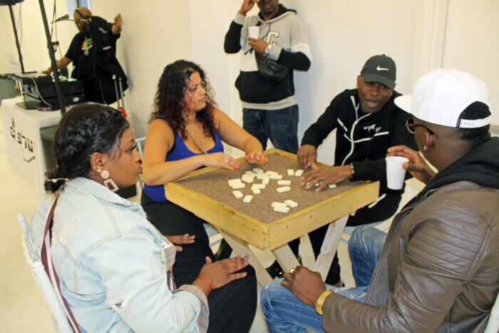 Women and men play a game of domino at the first ever recorded tournament in Brooklyn.
