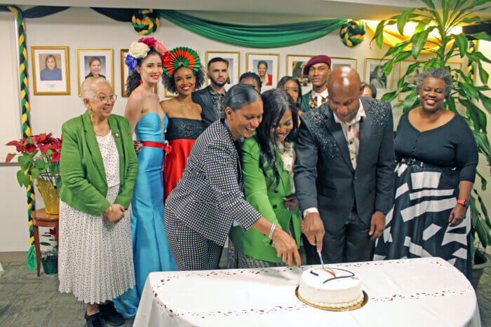 From left, Dr. Kurdell Campbell, consultant ER Physician Jamaica/Cayman, Consul General of Jamaica to New York, Alsion Roach Wilson, and Glenroy March, cut a 20th Anniversary cake at the book launch of “The Allure,” surrounded by friends, family and models.
