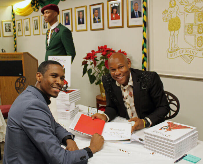 Vonroy Rochester, Jamaica deputy consul general, left, receives a signed copy of “The Allure” from author Glenroy March, creator of D'Marsh Couture, at a book-signing.