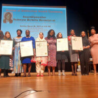 The 2023 Women of Distinction honorees on stage with electeds, holding Proclamations from Assemblymember Rodneyse Bichotte Hermelyn.