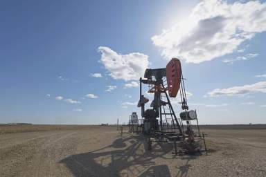 A pump jack in open ground at an oil extraction site.