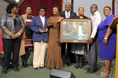 Congresswoman Clarke with portrait by Ghanaian autistic artist Amoako Buachie, flanked by CAGU members.