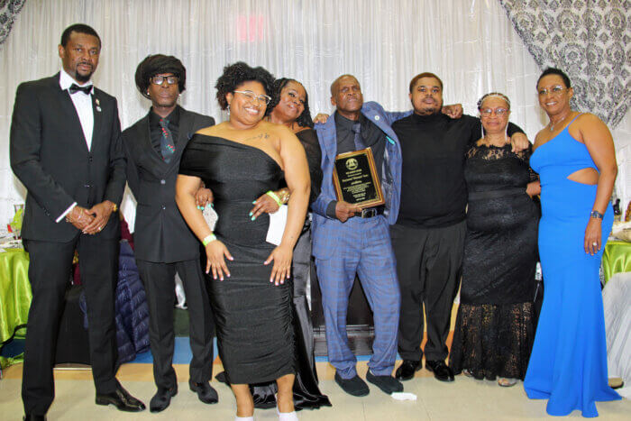 Raymond "Bicans" Soso, with plaque, flanked by family members, and Consul General Rondy "Luta" McIntosh (far left) his wife, Semone (far right).
